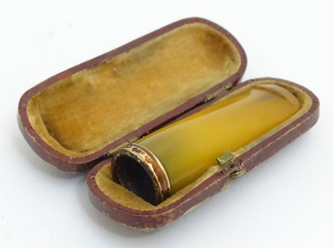 A cheroot mouthpiece of faux amber, contained within a: A cheroot mouthpiece of faux amber, contained within a leather case, 2 1/4 long.