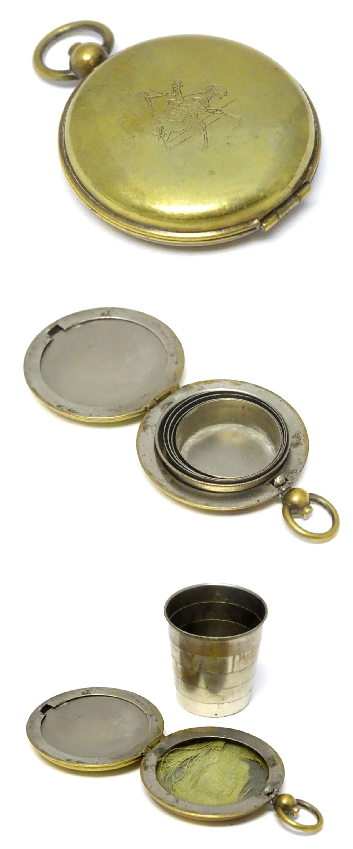 A telescopic / expandable tot cup / beaker within a: A telescopic / expandable tot cup / beaker within a case ( of pocket watch form) with engraved emu and figure decoration. The cup 1 1/2'' high ( expanded)