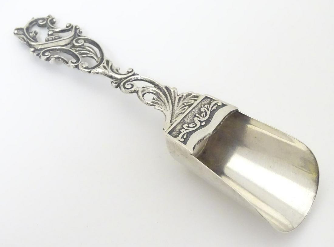 A Continental .800 silver caddy spoon with scroll: A Continental .800 silver caddy spoon with scroll decoration to handle. 4'' long