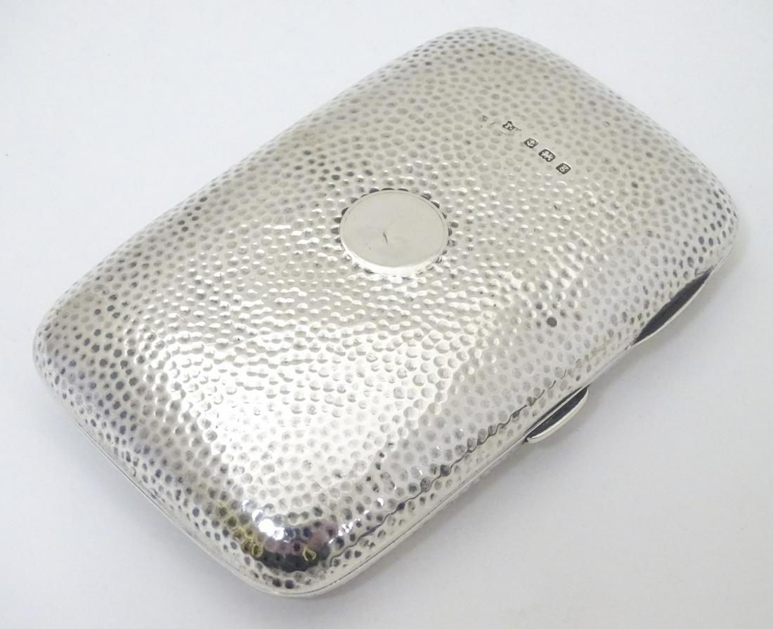 A silver cigar case with hammered decoration hallmarked: A silver cigar case with hammered decoration hallmarked Birmingham 1906 maker Thomas Bishton. 4 3/4'' x 3'' x 1/2'' (140g)