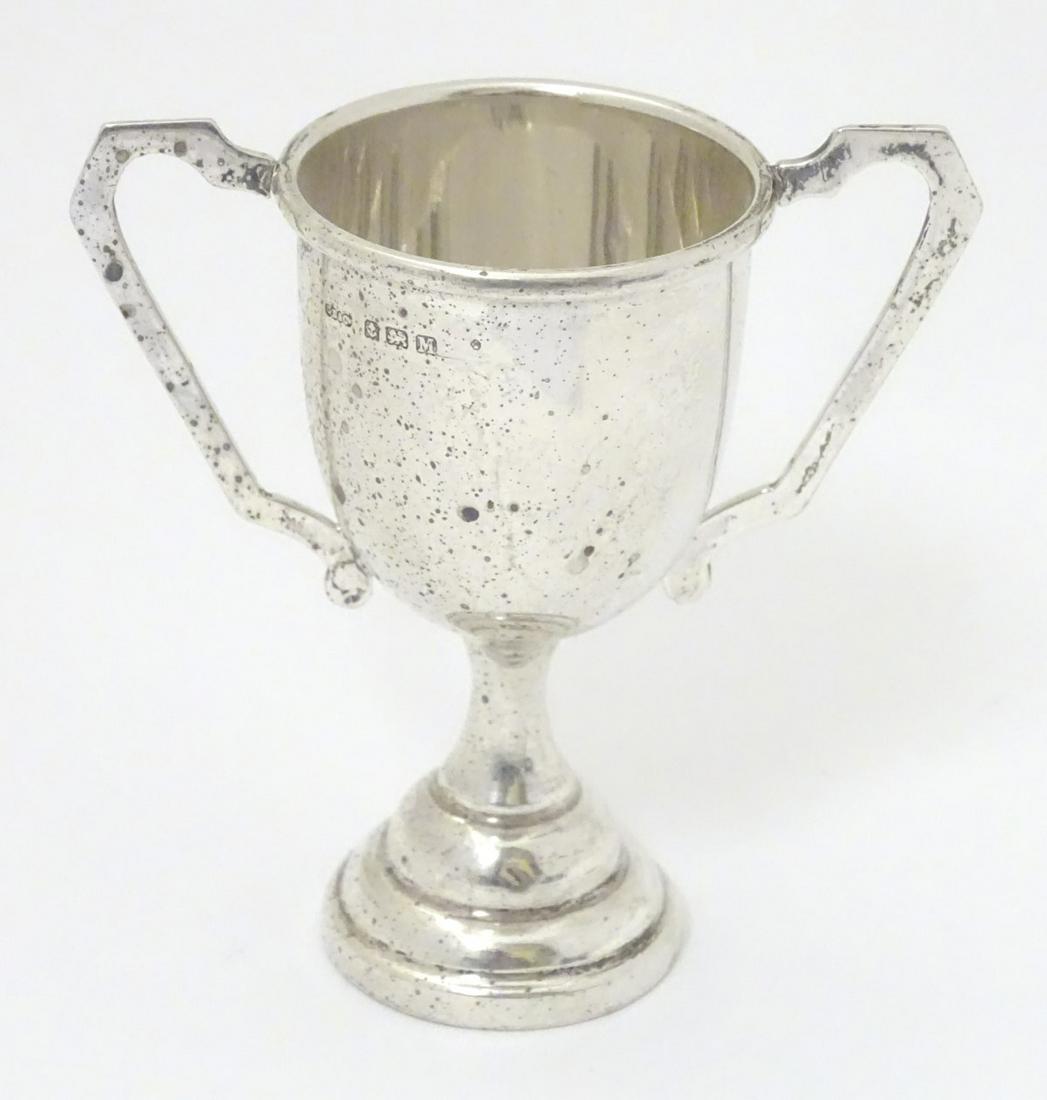 A silver trophy cup of pedestal form with twin handles.: A silver trophy cup of pedestal form with twin handles. Birmingham 1936 maker G Bryan & Co. 4 1/4'' high (36g)