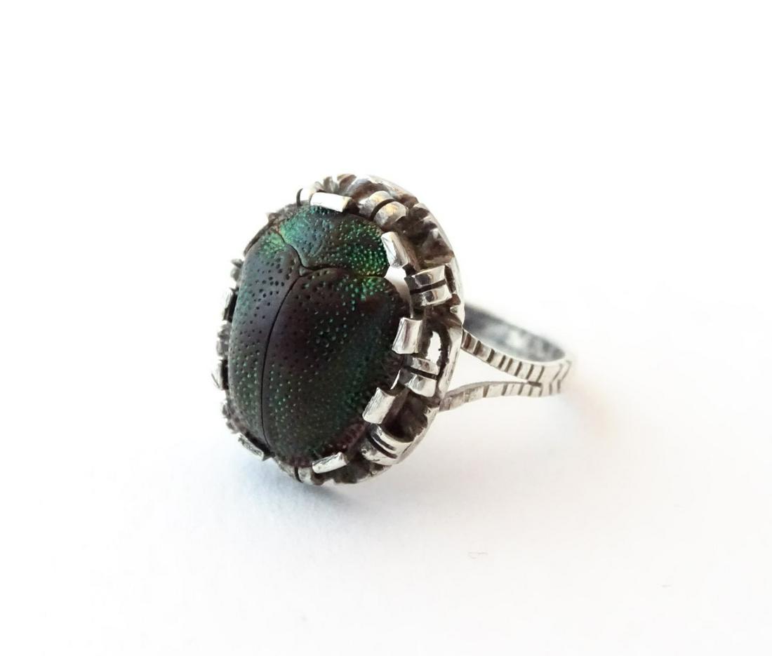 An early 20thC silver ring set with scarab beetle in: An early 20thC silver ring set with scarab beetle in the Egyptian Revival style. Ring size approx. L