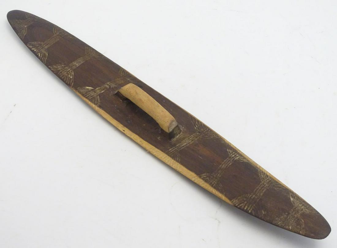 Ethnographic / Native / Tribal: An Aboriginal Wunda /: Ethnographic / Native / Tribal: An Aboriginal Wunda / Parrying shield with central handle and carved decoration. Approx. 25 1/2'' long.