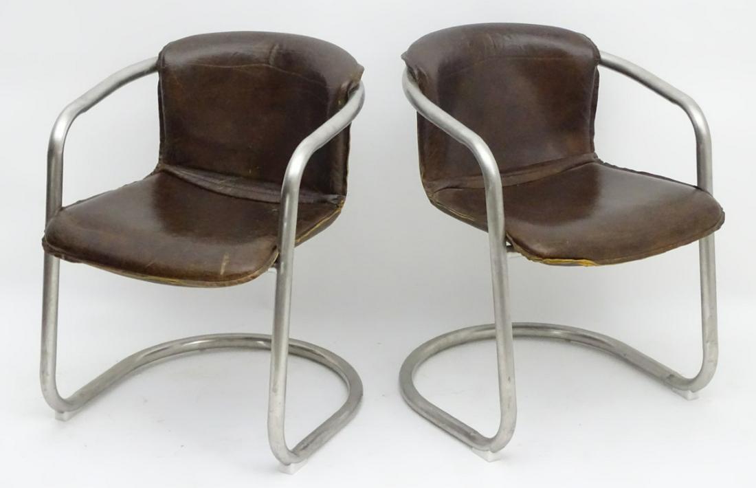 A pair of late 20thC cantilever open armchairs with: A pair of late 20thC cantilever open armchairs with chrome frames and tan leather upholstered backrest and seat. 22'' wide x 23'' deep x 29 ½'' high