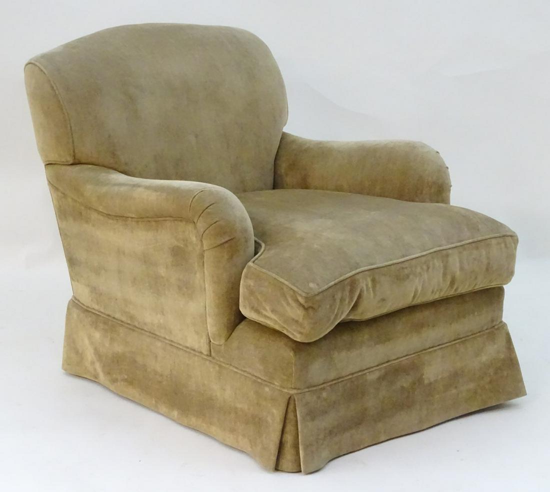 A Howard and Sons style armchair with shaped backrest,: A Howard and Sons style armchair with shaped backrest, drop in seat and low hanging trim. 31'' wide x 42'' deep x 33'' high