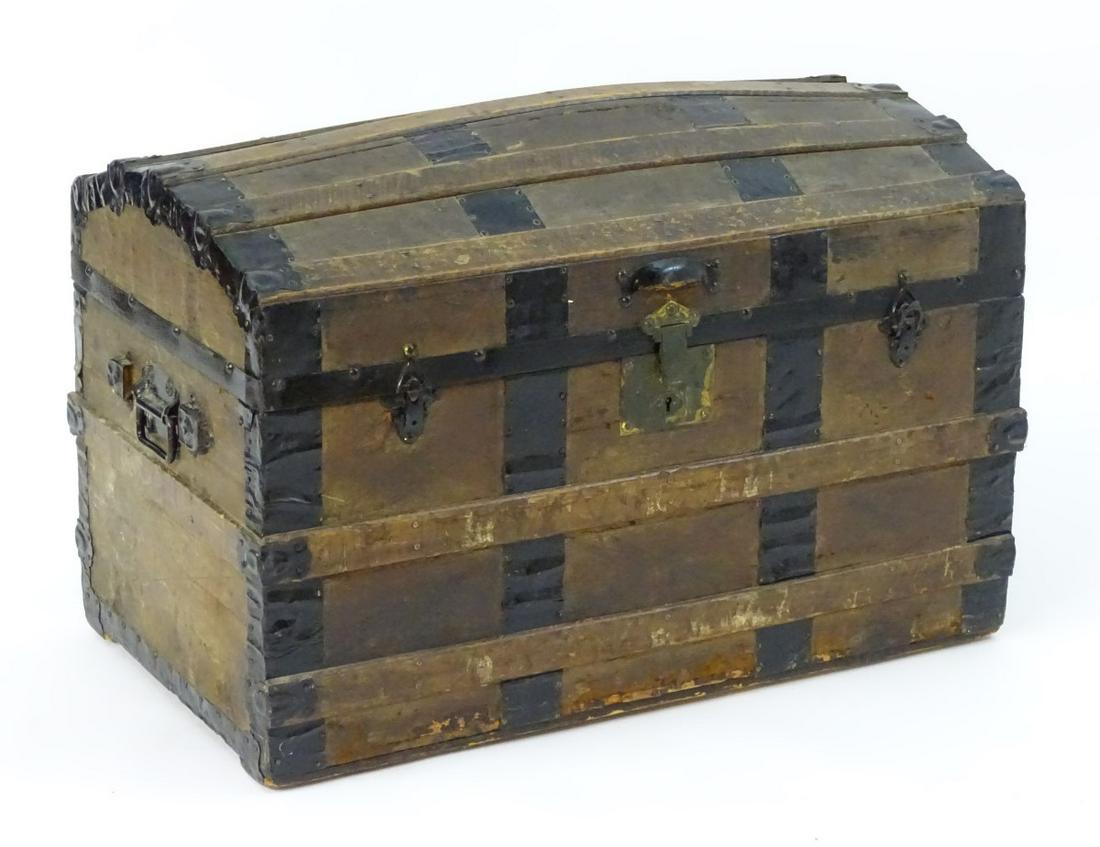 An early 20thC casket with wrought iron strapping and: An early 20thC casket with wrought iron strapping and flanked by carrying handles to each side. 32'' long x 18'' wide x 22'' high