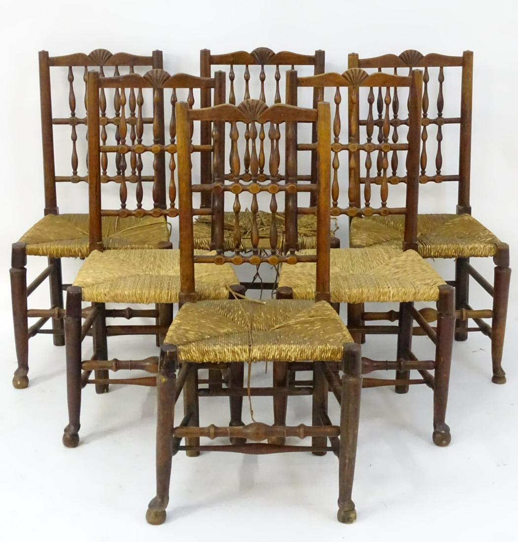 A set of six fruitwood spindle back chairs with carved: A set of six fruitwood spindle back chairs with carved cresting rails, envelope rush sears and standing on turned legs and united by double braced box stretchers. 19 1/2'' wide x 16 1/2'' deep x 39'' 