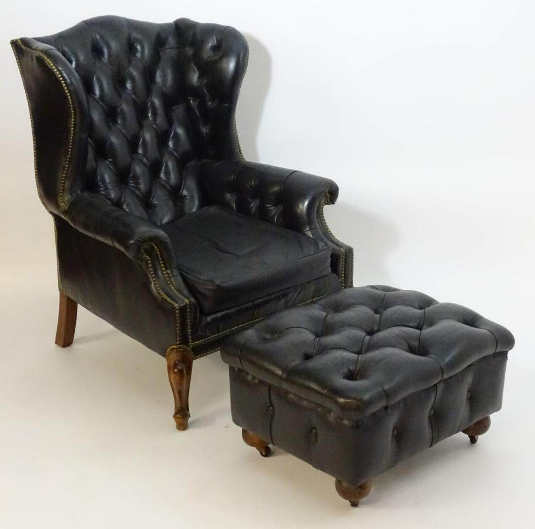 A mid 20thC Chesterfield style wingback armchair and: A mid 20thC Chesterfield style wingback armchair and footstool, the chair having brass stud detailing and scrolled arms above carved cabriole front legs. The stool with deep buttoned upholstery and ra