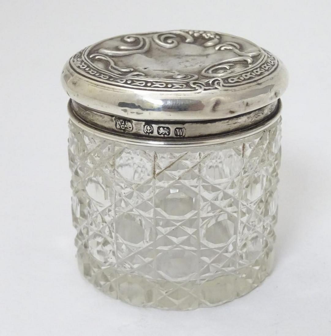 A cut glass dressing table pot with silver top: A cut glass dressing table pot with silver top hallmarked Birmingham 1921 maker A J Pepper & Co. Ltd. 2" high overall