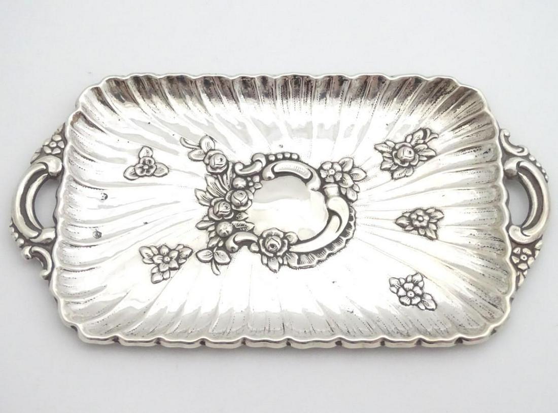 A late 19thC Spanish silver dressing table tray with: A late 19thC Spanish silver dressing table tray with embossed decoration. 6 1/4" wide (64g)
