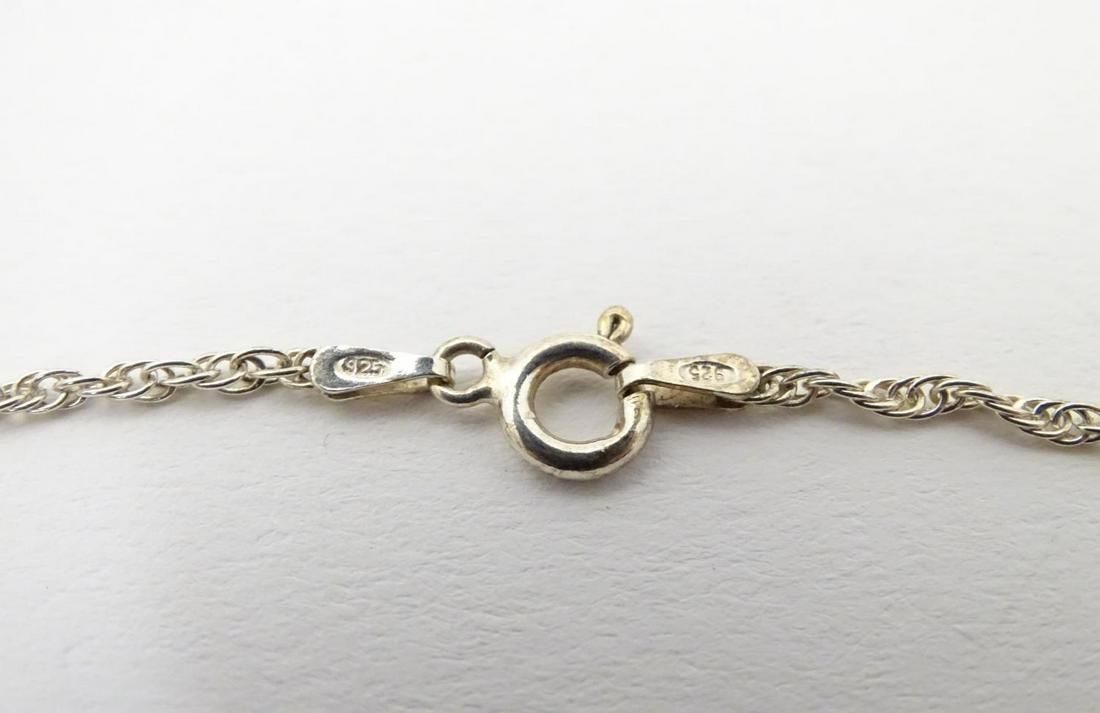 A silver necklace with heart chaped pendant set with: A silver necklace with heart chaped pendant set with pale blue stones. The whole approx 19" long