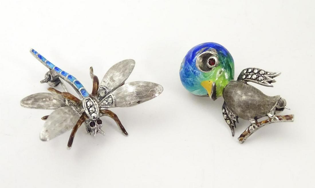 A silver brooch formed as a novelty / cartoon bird with: A silver brooch formed as a novelty / cartoon bird with guilloche enamel decoration red stone and marcasite detail. marked Sterling. Together with a white metal brooch formed as a dragon fly with guil