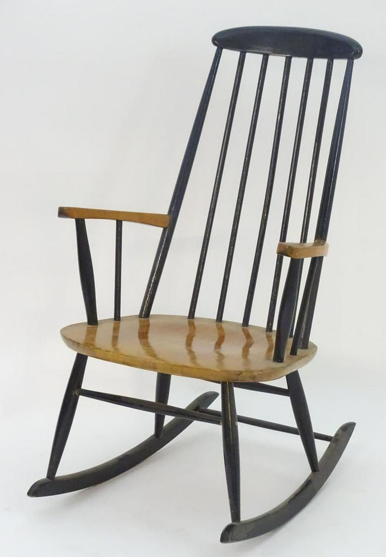 A mid / late 20thC Windsor style rocking chair, with a: A mid / late 20thC Windsor style rocking chair, with a shaped top rail and turned backrests and supports with swept armrests. Having turned stretchers and legs descending to two shaped rockers. 24" wi