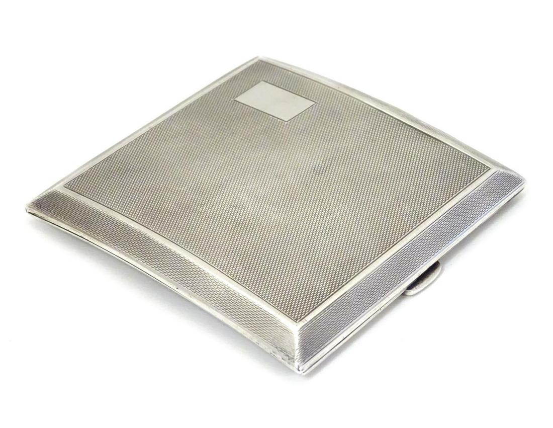 An Art Deco silver cigarette case of shaped form with: An Art Deco silver cigarette case of shaped form with engine turned decoration. Hallmarked Birmingham 1934 maker Mappin & Webb Ltd. 3 1/2" x 3 1/2"(118g)