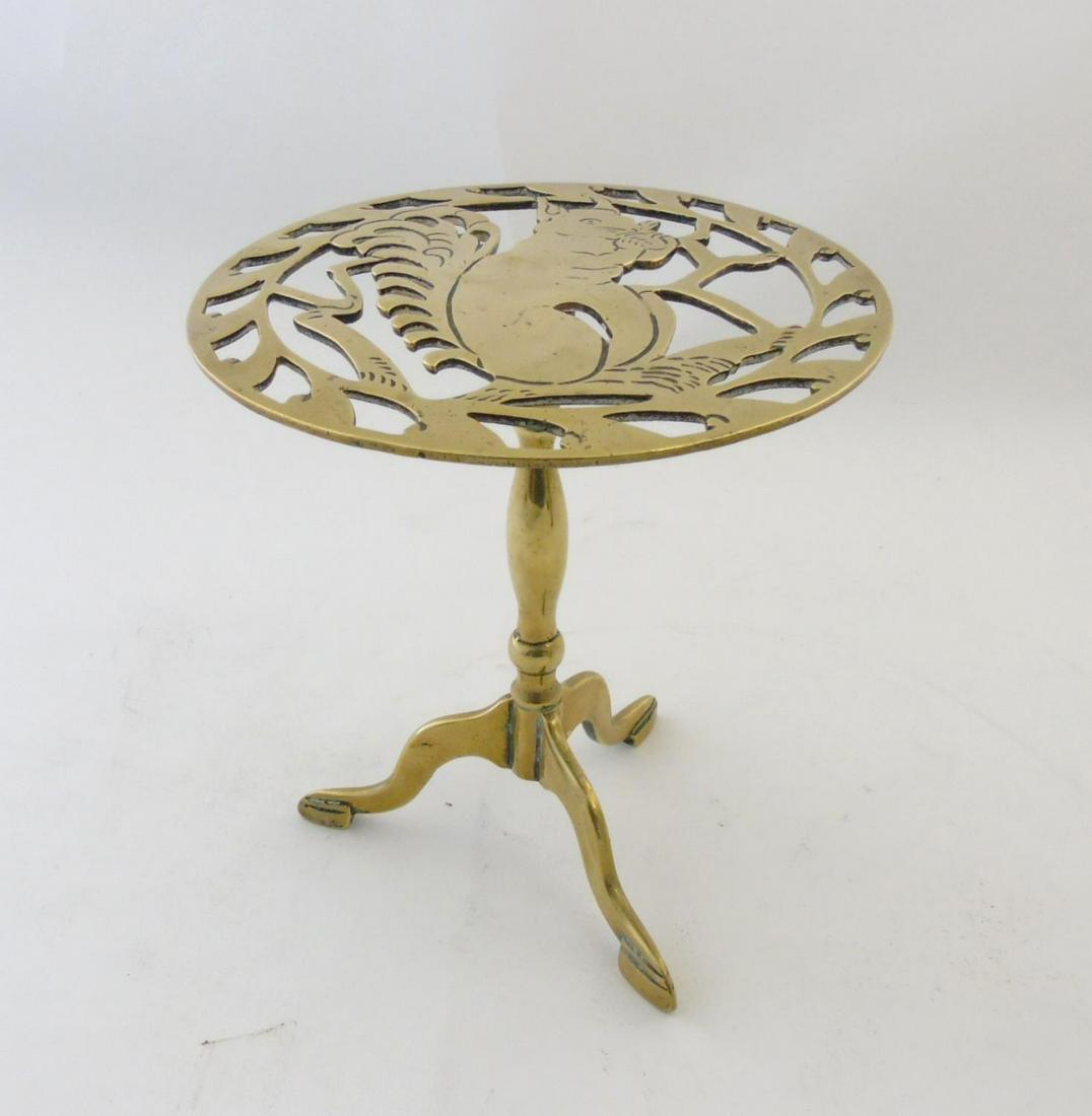 A Victorian brass trivet with pierced squirrel: A Victorian brass trivet with pierced squirrel decoration and triform foot. 8" diameter x 8 1/2" high Condition Report Please Note - we do not make reference to the condition of lots within descriptio