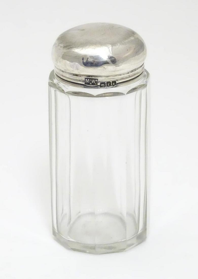 A glass toilet jar with silver top hallmarked London: A glass toilet jar with silver top hallmarked London 1901 maker Mappin & Webb Ltd. 3 1/2" high.