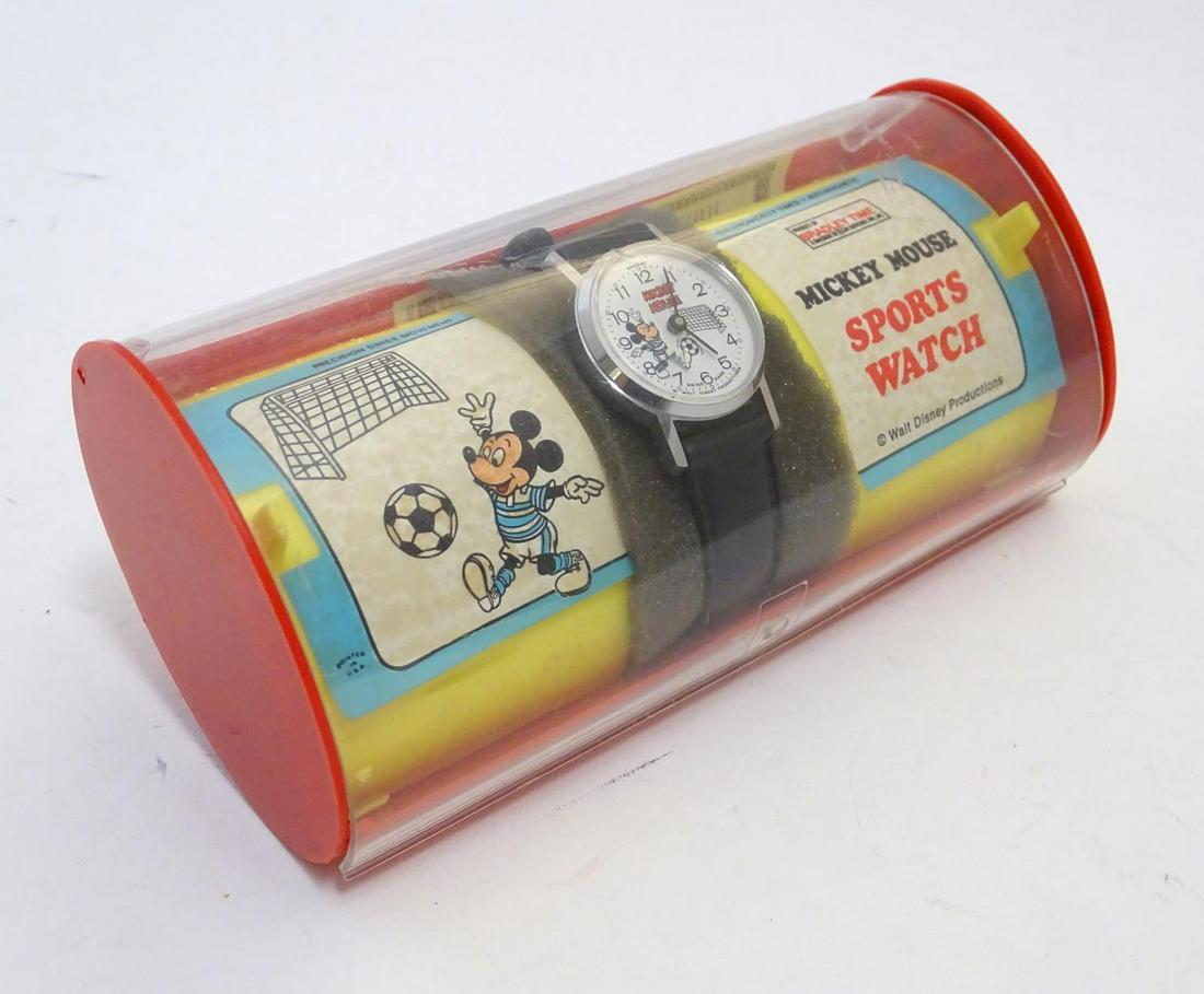 Toy: A Bradley Time Mickey Mouse Sports Watch, the: Toy: A Bradley Time Mickey Mouse Sports Watch, the crown at 2 o'clock, the dial with Mickey Mouse playing football / soccer, with an articulated leg as if kicking a ball, contained within a Walt Disne