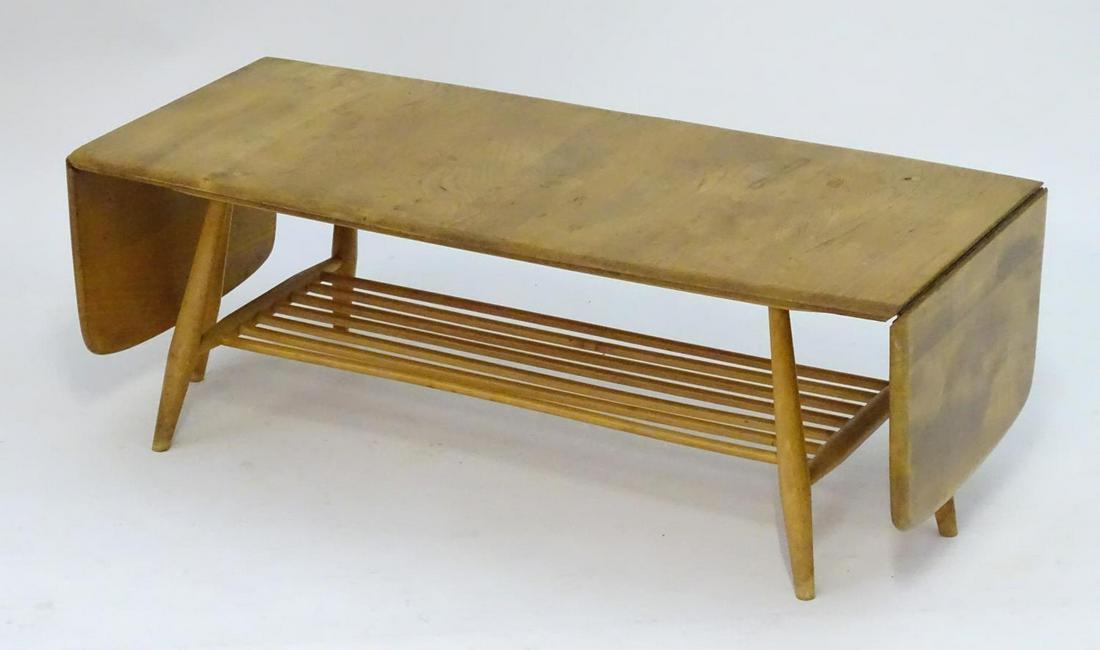 Vintage Retro, Mid-Century: an Ercol elm and beech: Vintage Retro, Mid-Century: an Ercol elm and beech coffee table, extending with drop flaps, standing on six legs united by a slatted stretcher forming a magazine rack. 63" long (extended), 18" wide, 1