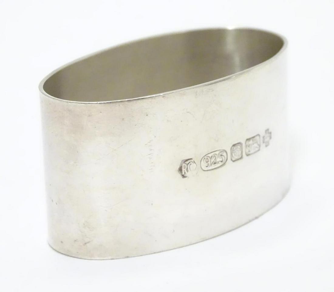 A silver napkin ring of oval form. Hallmarked London: A silver napkin ring of oval form. Hallmarked London 2000 maker Carr's of Sheffield Ltd.