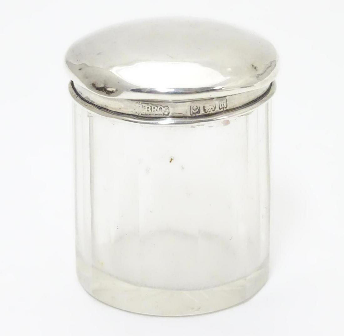 A glass dressing table pot with silver top hallmarked: A glass dressing table pot with silver top hallmarked Birmingham 1905 maker M bros. 2" high