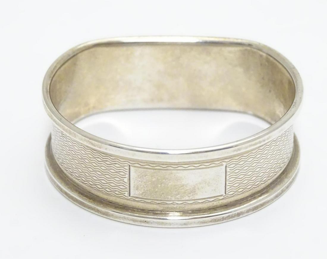 A silver napkin ring with engine turned decoration: A silver napkin ring with engine turned decoration hallmarked Birmingham 1988 maker B& Co.