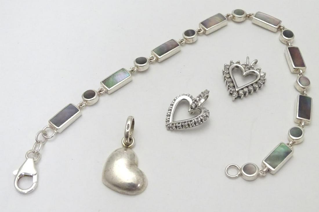 A silver bracelet set with abalone shell detail: A silver bracelet set with abalone shell detail together with and 3 assorted charms (4)