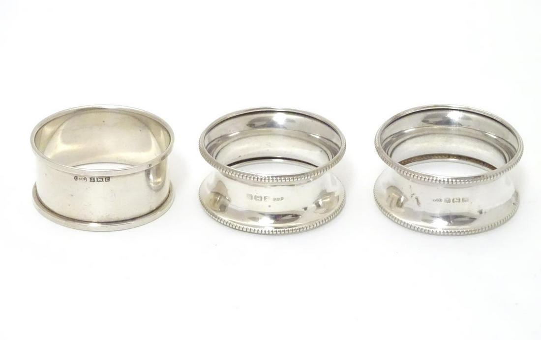 A pair of silver napkin rings hallmarked Birmingham: A pair of silver napkin rings hallmarked Birmingham 1927 maker E Edmonds together with another hallmarked Birmingham 1954 maker W I Broadway & Co (3)