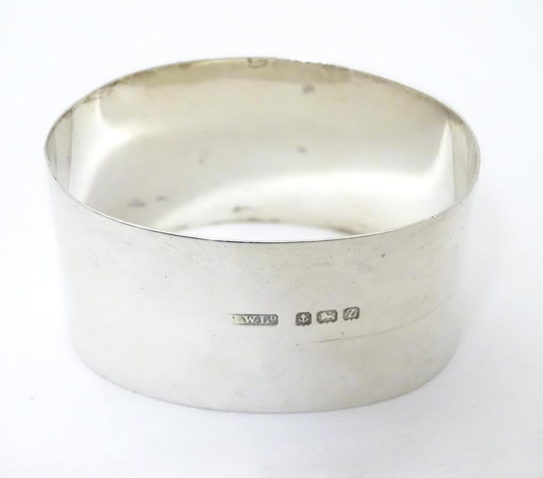 A silver napkin ring of ovoid form hallmarked: A silver napkin ring of ovoid form hallmarked Birmingham 1924 maker Henry Williamson Ltd.