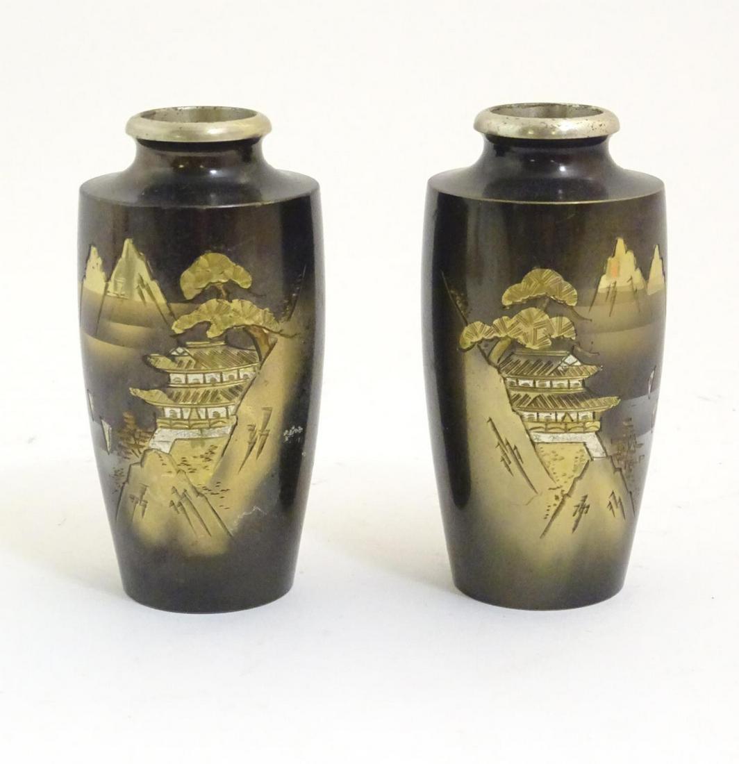 A pair of Oriental vases with chokin style engravings: A pair of Oriental vases with chokin style engravings depicting a mountain landscape scene with a pagoda. Approx. 4 1/4" high (2)