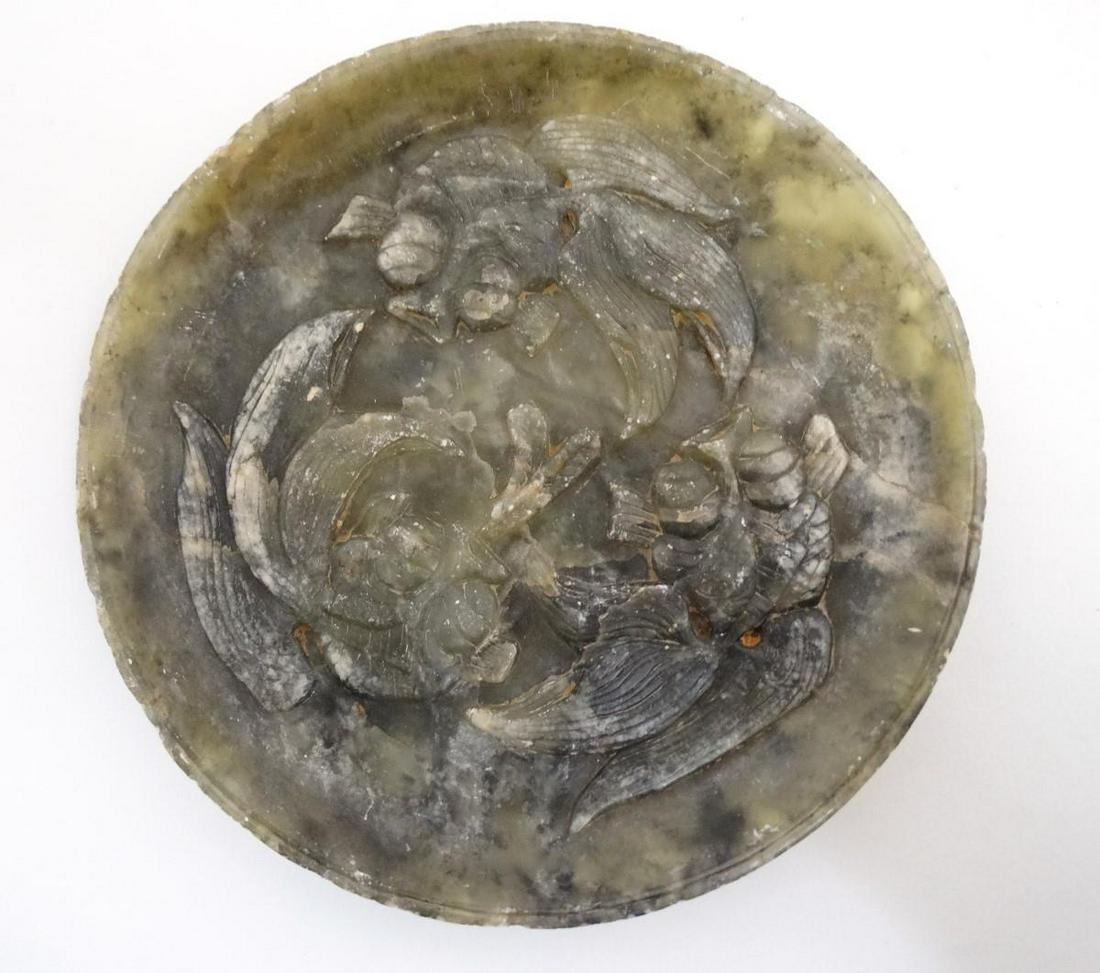 An Oriental carved soapstone plate depicting three carp: An Oriental carved soapstone plate depicting three carp / koi fish in relief. Approx. 7 1/8" diameter