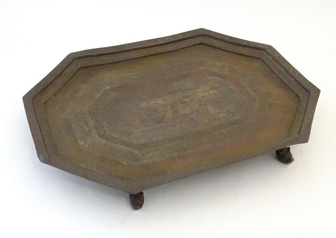 An Indian tray depicting a deity, possibly Vishnu, on a: An Indian tray depicting a deity, possibly Vishnu, on a bed of serpents / snakes with attendants and banded foliate decoration. Raised on four animal head formed feet. Approx. 15 3/4" x 21 1/4" Catego