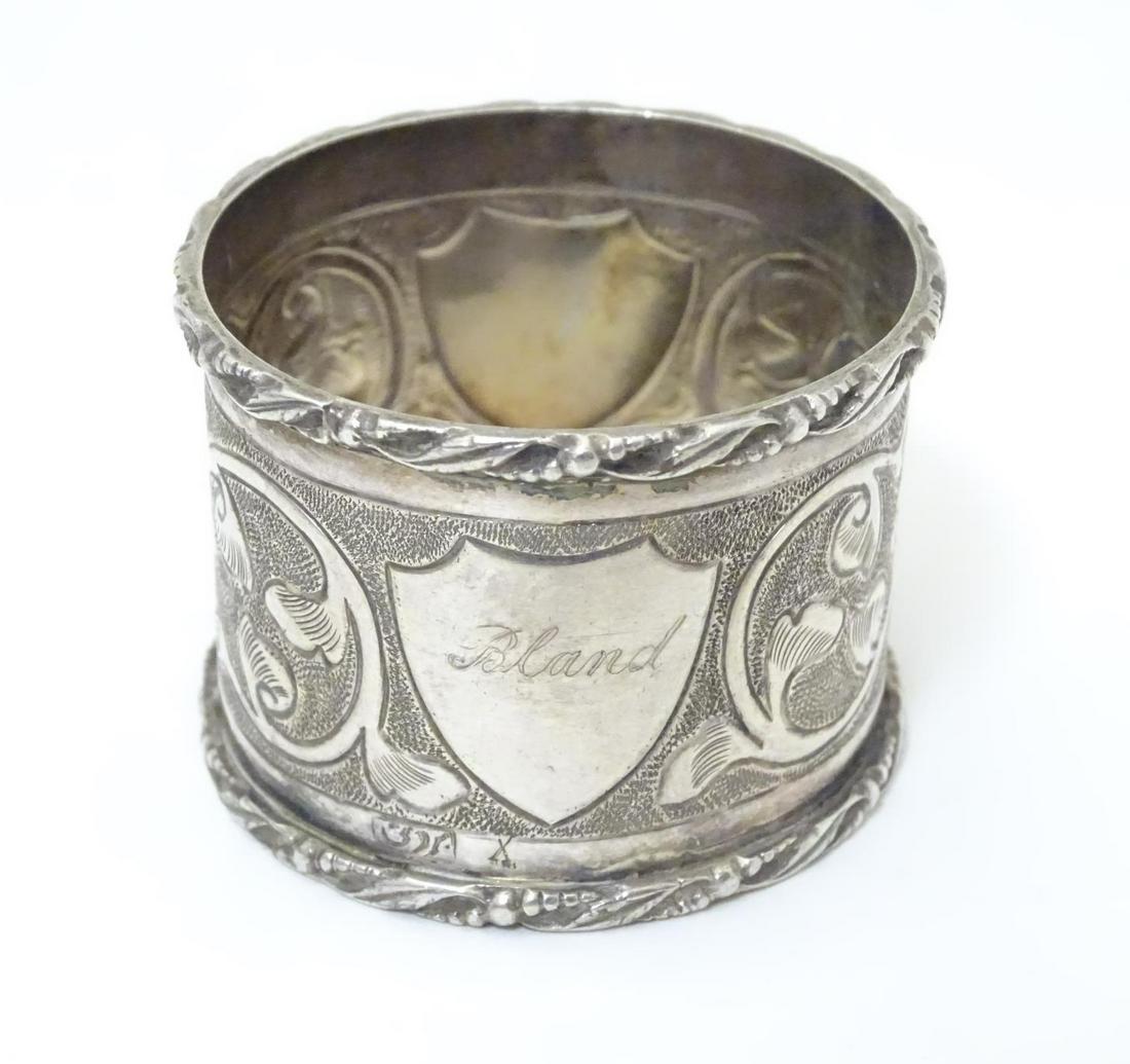 A white metal napkin ring with engraved decoration,: A white metal napkin ring with engraved decoration, probably Indian, indistinctly marked.