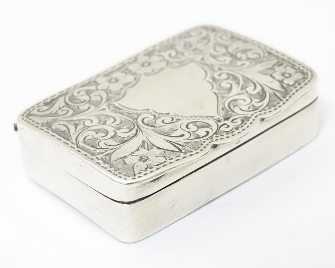 A silver pill box with engraved decoration to the: A silver pill box with engraved decoration to the hinged lid, hallmarked Birmingham 1905, maker Adie & Lovekin Ltd. Approx. 1 3/4" x 1 1/4" x 1/4"