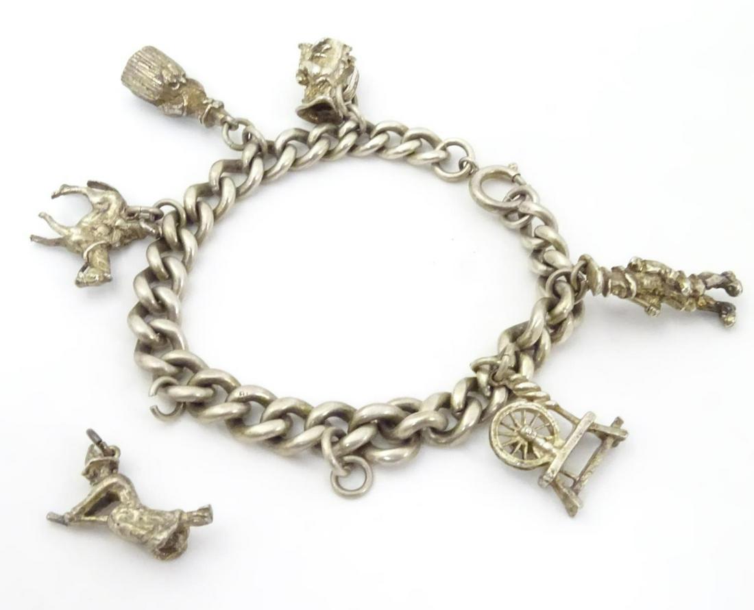 A silver charm bracelet set with white metal charms (1 of 8)