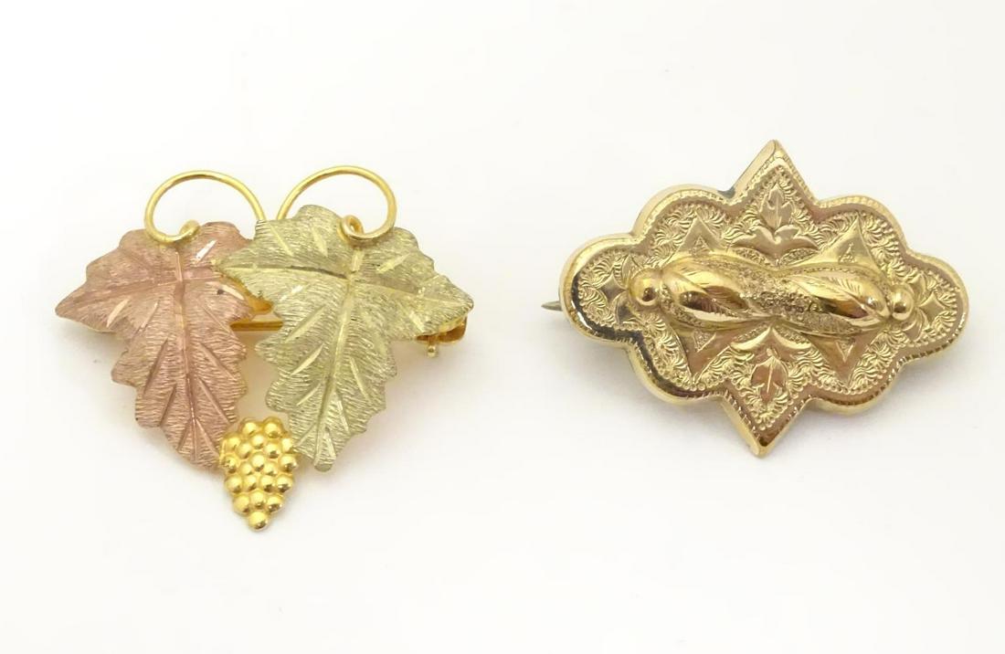 A 9ct gold brooch formed as a fruiting vine. Together (1 of 9)