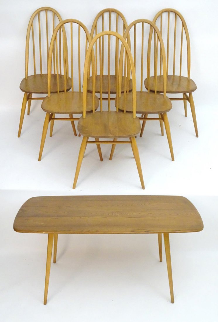 A vintage retro Ercol dining table and set of six: A vintage retro Ercol dining table and set of six chairs, the figured elm table having rounded edges and four tapering legs, the six chairs having hooped stick backs and standing on turned tapering le