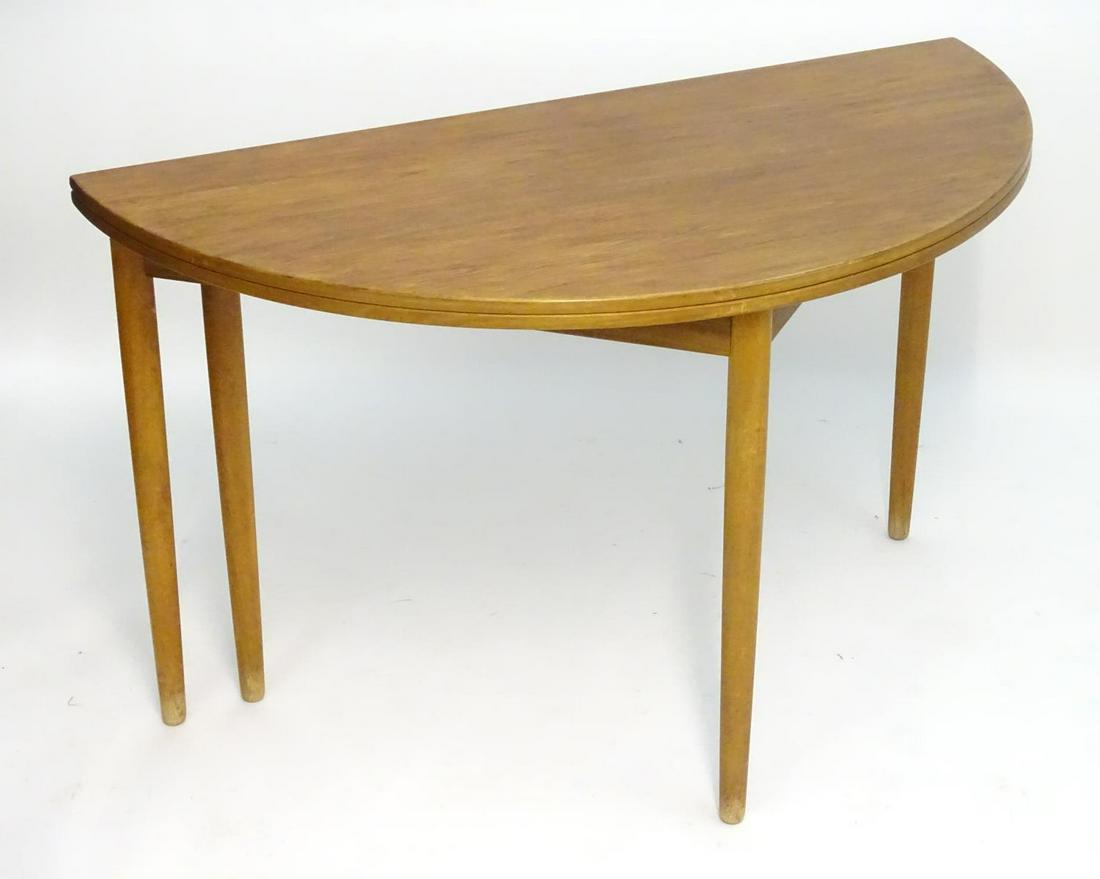 Vintage retro, mid century: a Danish teak foldover: Vintage retro, mid century: a Danish teak foldover table by Frem Rojle, the demi lune top unfolding to circular form, stamped underside with maker's name and labelled Danish Furniture Makers Control,