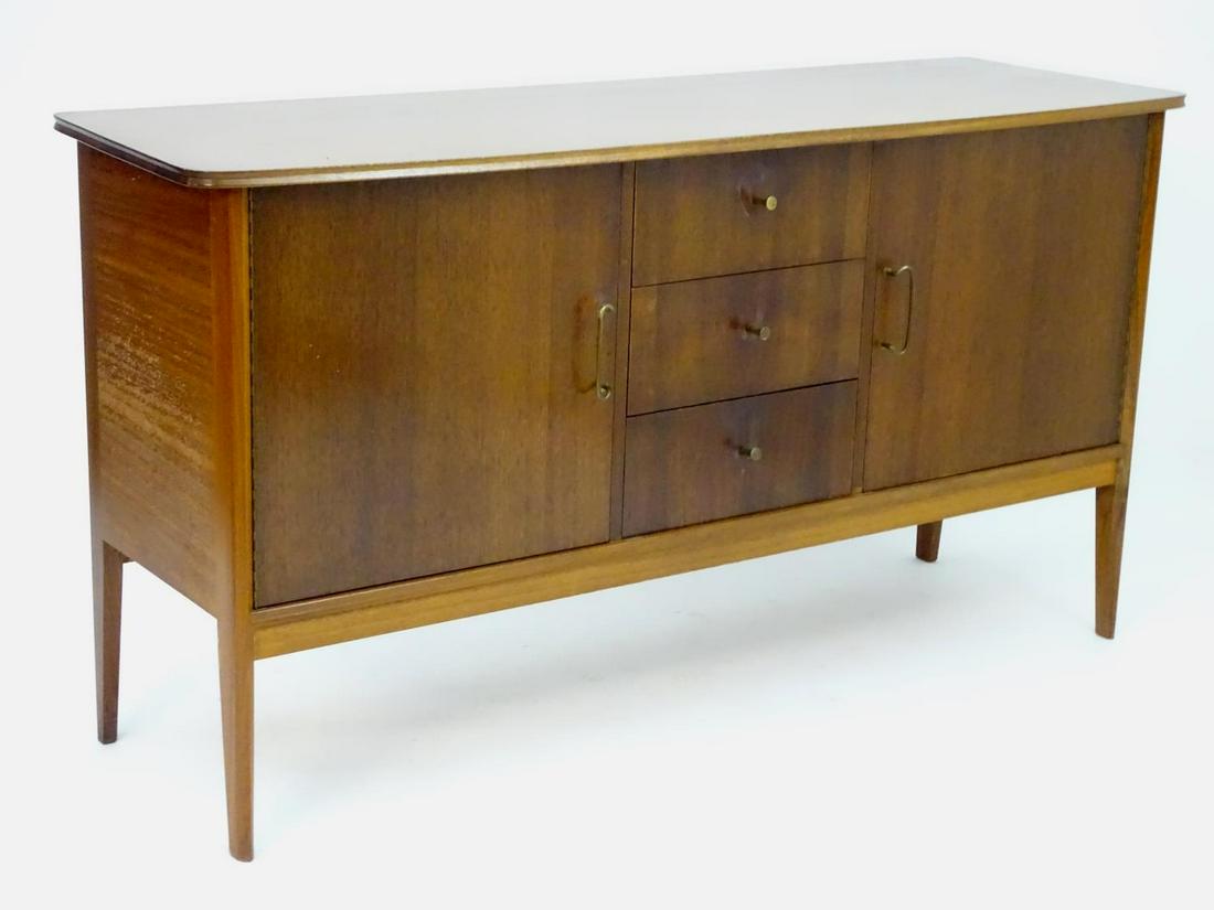 Vintage retro, Mid-century : Peter Hayward for W.G.: Vintage retro, Mid-century : Peter Hayward for W.G. Evans (Vanson). A 1950s walnut sideboard fitted with 3 central drawers flanked by a single cupboard at either side, brass handles and tapered legs.