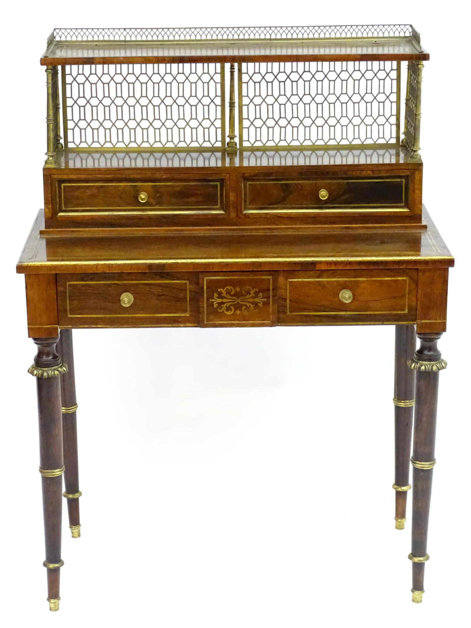 A Regency period rosewood bonheur du jour attributed to: A Regency period rosewood bonheur du jour attributed to John Mclean, having a pierced brass gallery superstructure above two short drawers. Having gilt painted mouldings and brass inlaid stringing to