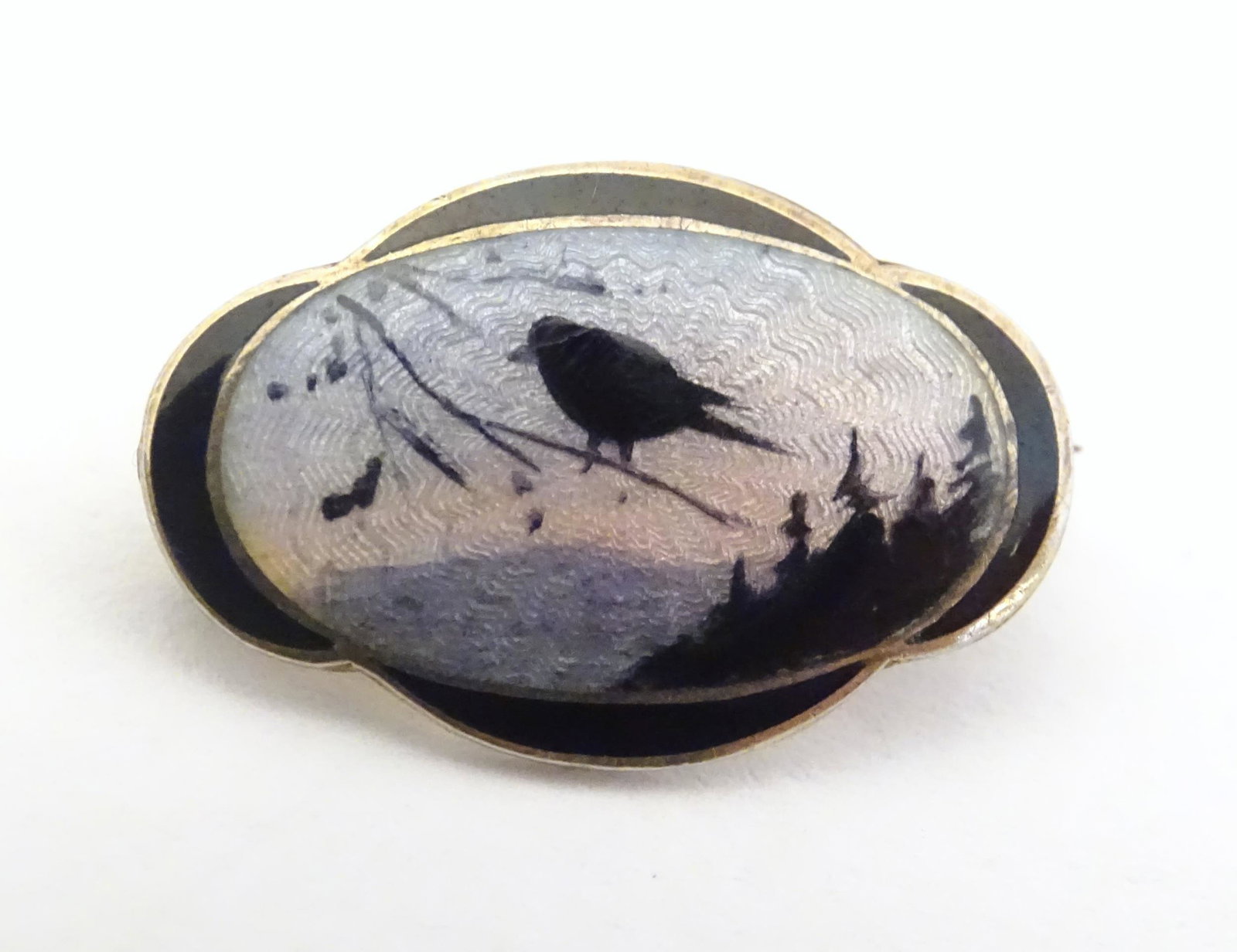 Scandinavian Jewellery : A Norwegian silver brooch with: Scandinavian Jewellery : A Norwegian silver brooch with guilloche enamel and silhouette detail depicting a bird on a branch. Maker Clement Berg Norway 3/4" wide