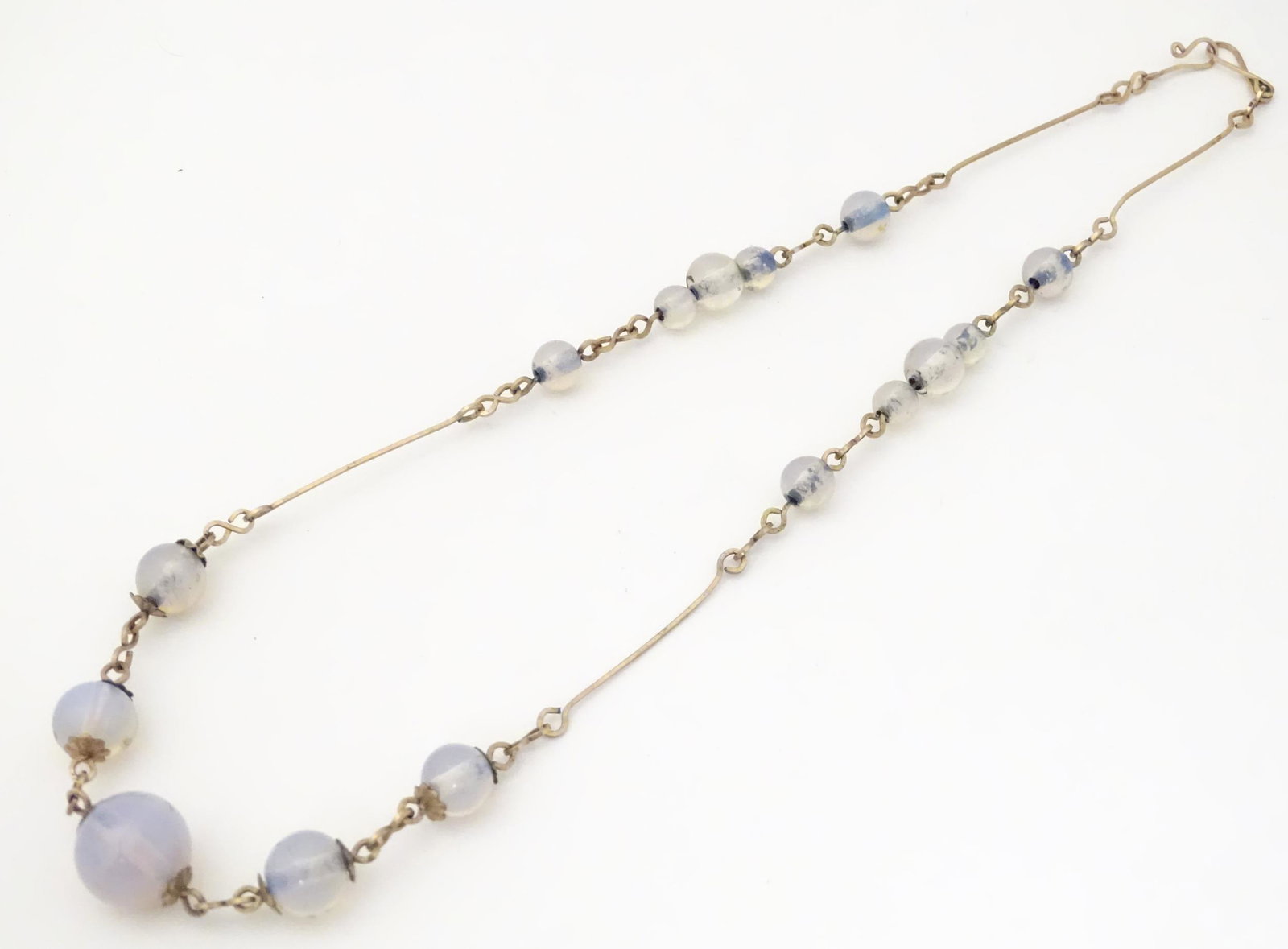 A gilt metal necklace set with gradated opaline glass: A gilt metal necklace set with gradated opaline glass beads. Aprrox 16" long