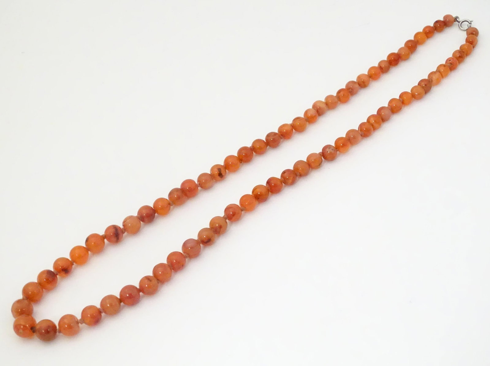 A necklace of graduated carnelian hardstone beads.: A necklace of graduated carnelian hardstone beads. Approx 26" long
