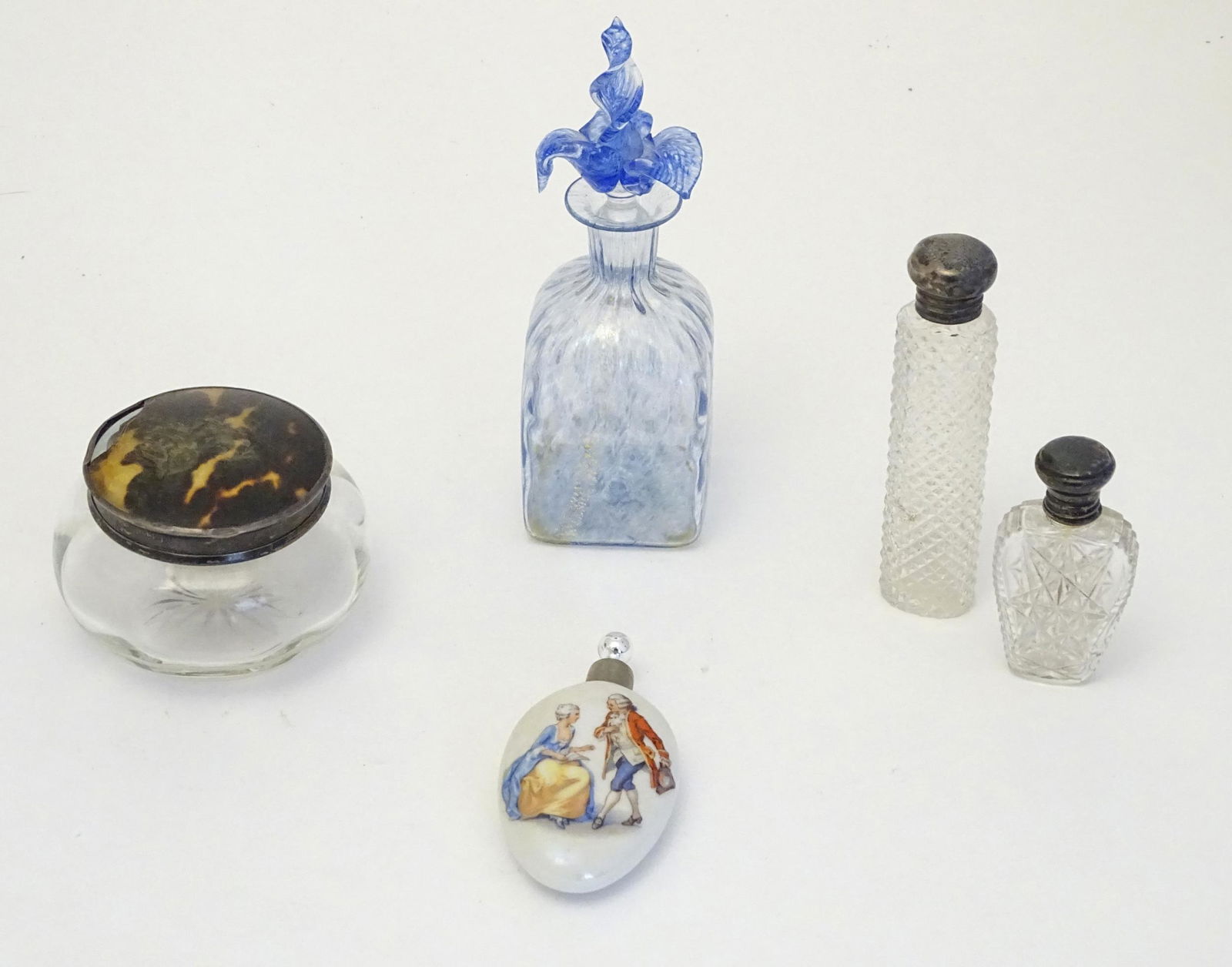 Assorted scent perfume flasks to include a two cut: Assorted scent perfume flasks to include a two cut glass flasks with silver tops, a scent bottle with blue and gilt detail a ceramic scent flask and glass dressing table pot. The tallest 5 1/2" high (