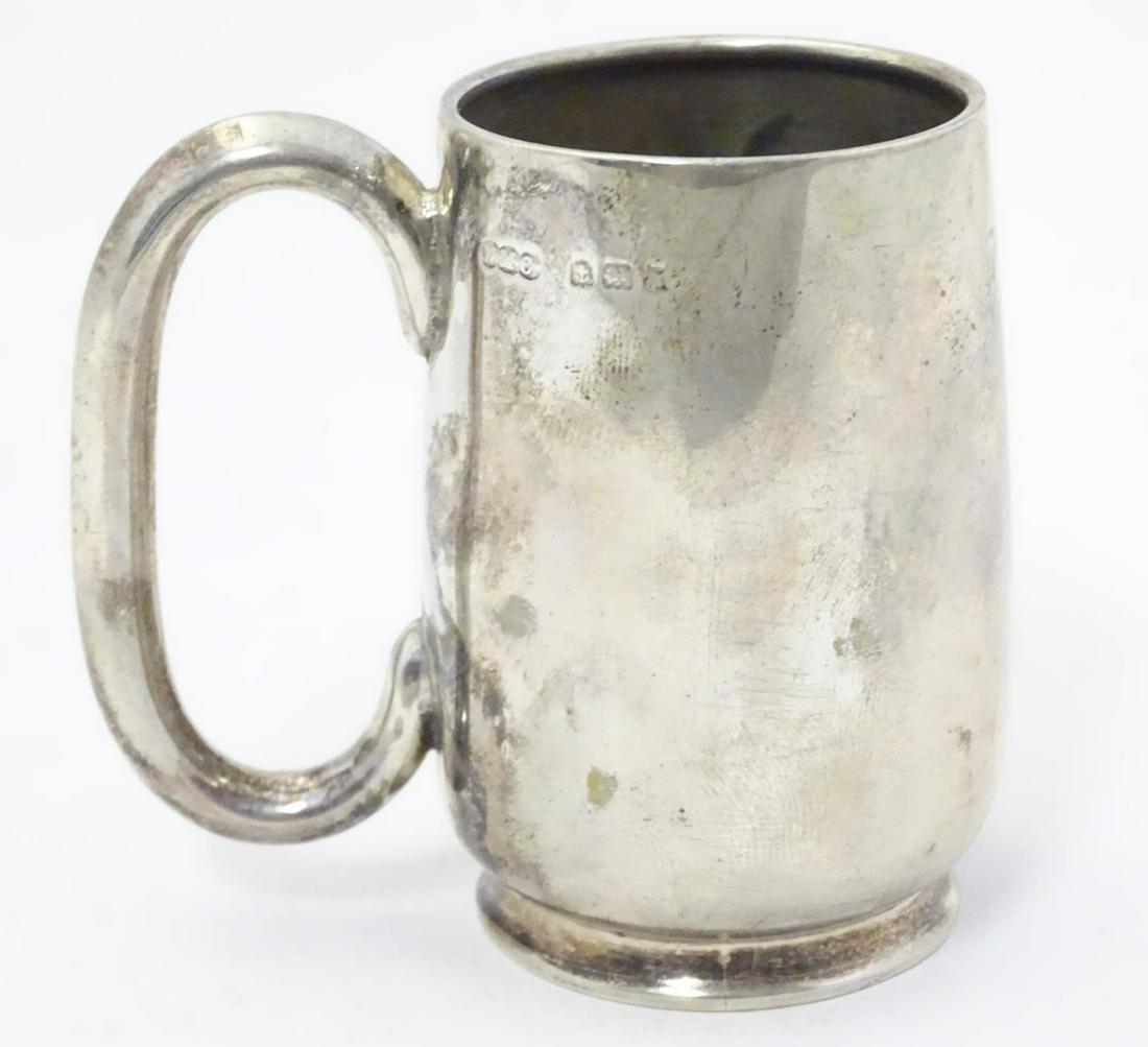 A silver christening mug with loop handle. Hallmarked: A silver christening mug with loop handle. Hallmarked Birmingham 1918 maker Wilmot Manufacturing Co. Approx. 2 1/2" high.