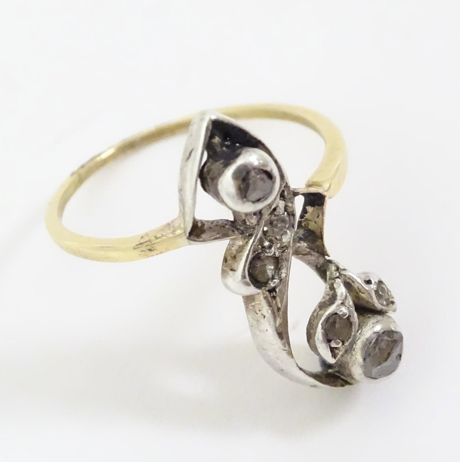 A yellow metal ring set with diamonds in a foliate (1 of 7)