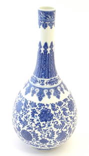 A Chinese blue and white bottle vase decorated with scrolling flowers and foliage, the neck with: A Chinese blue and white bottle vase decorated with scrolling flowers and foliage, the neck with banded detail. Character marks under. Approx. 19" high