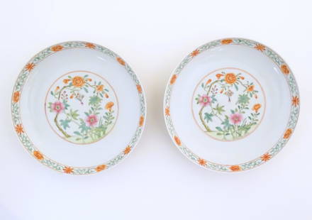 A pair of Chinese plates / dishes with central roundels depicting flowers and a foliate border. The: A pair of Chinese plates / dishes with central roundels depicting flowers and a foliate border. The reverse with a yellow ground decorated with scrolling foliage and vase motifs. Character marks