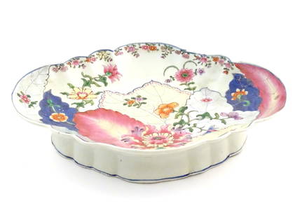 A Chinese export famille rose footed serving dish of lozenge form in the tobacco leaf pattern with: A Chinese export famille rose footed serving dish of lozenge form in the tobacco leaf pattern with flowers and foliage. Approx. 3 1/4" high x 14 1/4" wide x 10 3/4" deep