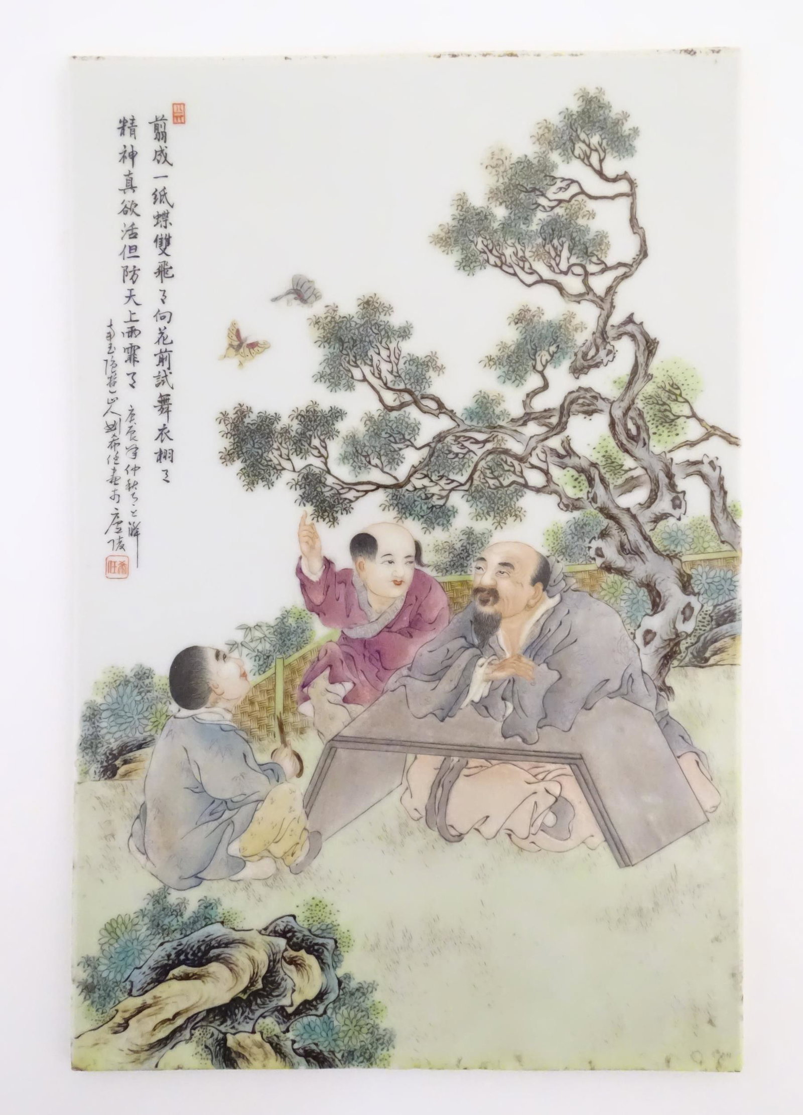A Chinese porcelain plaque decorated with three seated male figures in a garden terrace watching (1 of 4)