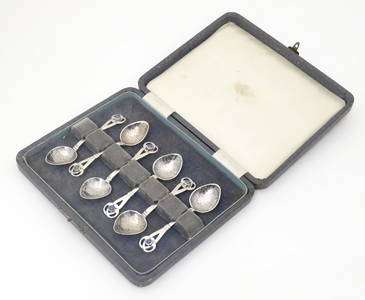 A set of six Arts & Crafts silver tea spoons with hammered decoration to bowls and pierced terminals